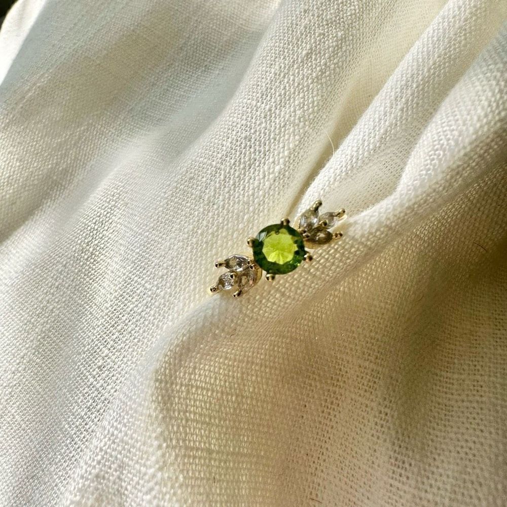 Light green round cut cubic zirconia ring with marquis on each side